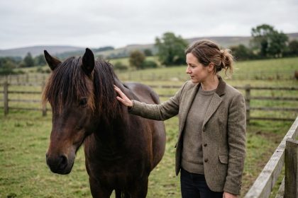 Femme avec un cheval dans un paddock naturel