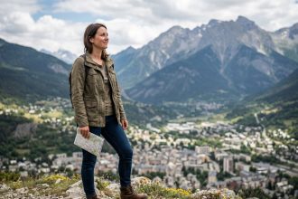 Femme en randonnée avec carte sur un panorama alpin